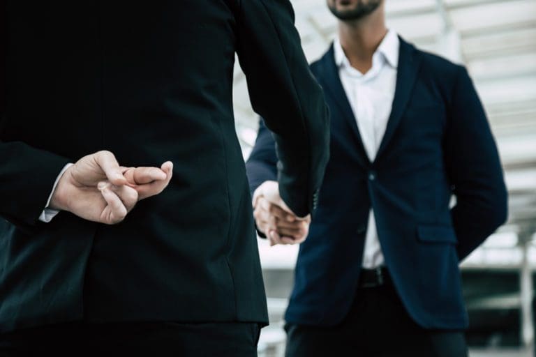 Businessman or politician cross finger, hiding behind his back during ...